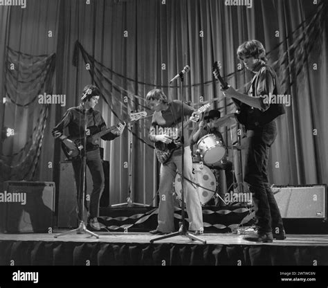 Four piece, all male rock 'n' roll band performing on stage in the 60's ...