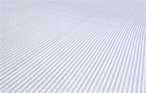 rolled and groomed ski slope, rilled snow background texture in winter ...