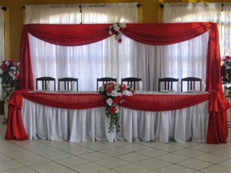 a banquet table set up with red and white flowers