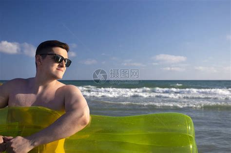 海边滩上的男人有游泳床垫高清图片下载-正版图片505452973-摄图网