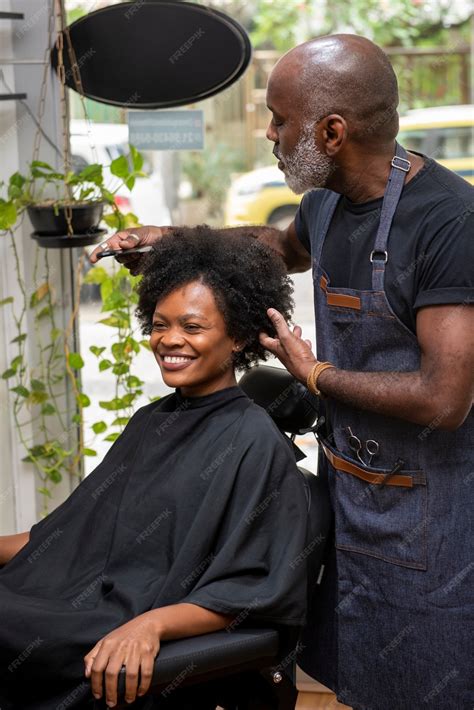 Premium Photo | Latino hair salon owner taking care of client