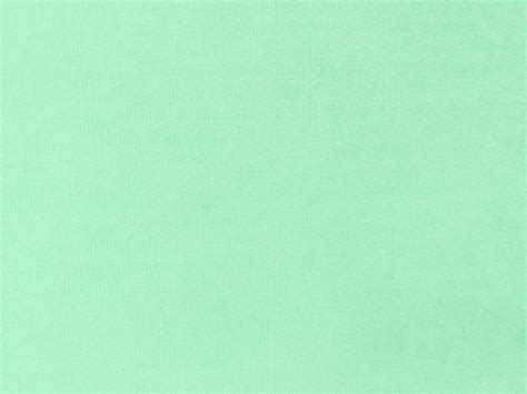 mint green velvet fabric texture used as background. Empty light orange ...