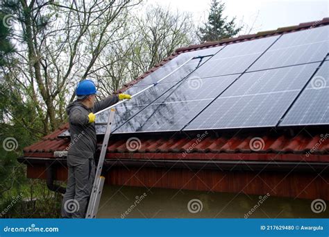 A Man on a Ladder Cleaning Solar Panels Stock Photo - Image of clear ...
