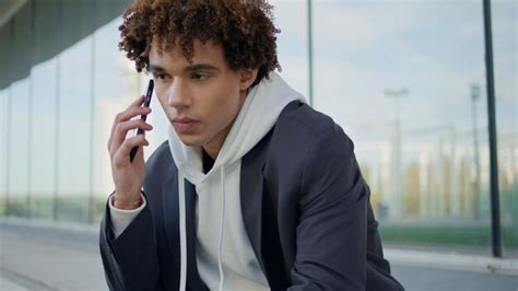 Relaxed teen calling mobile at glass wall place portrait smiling guy ...