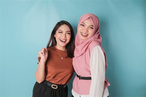 Portrait of two cheerful asian women standing and laughing isolated on ...
