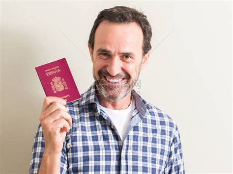 老人拿着西班牙护照脸上笑着站自信地高清图片下载-正版图片503393547-摄图网