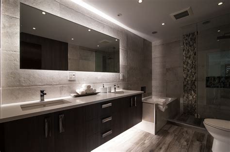 Large rectangular wall mirror in bathroom with glowing lighting fixture ...