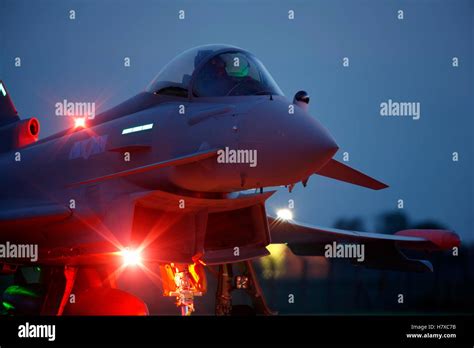Royal Air Force ground crew preparing an RAF Typhoon fighter jet. It is night-time and the team are