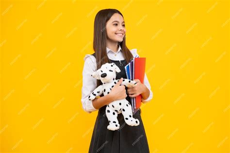 Powrót do szkoły Nastoletnia uczennica trzyma książkę z zabawką gotową ...