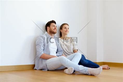 抵押贷款、人和房地产概念-幸福的夫妻坐在新家空房间的地板上。高清摄影大图-千库网