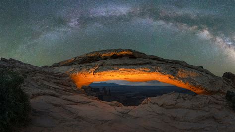 Milky Way Galaxy panorama over a lit Mesa Arch in Canyonlands National ...