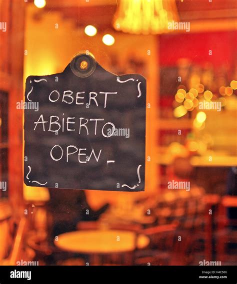 Open sign in english, catalan and spanish languages Stock Photo - Alamy
