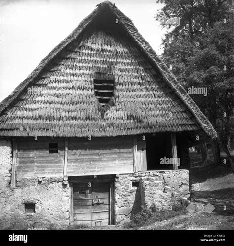 The 1954 photograph depicts a traditional Slovenian farmhouse and barn ...