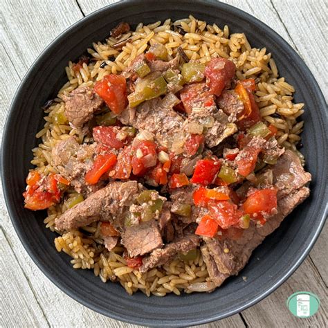 A bowl of slow cooker pepper steak, served over white rice