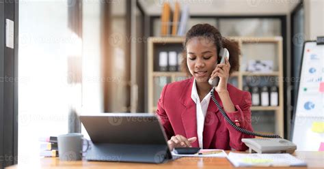 mujer de negocios afroamericana feliz hablando por móvil en la oficina ...