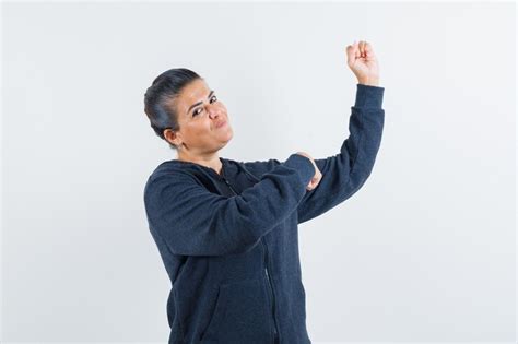 Female in hoodie showing muscles of arm and looking confident , front ...