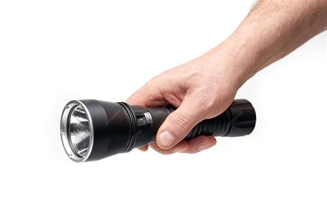 Black flashlight in hand on a white background | Premium Photo