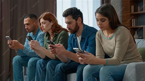 Premium Photo | Sad man look at friends mobile phone addicted multiracial people lost in gadgets ...