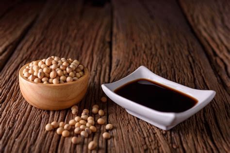 Soy sauce with soy bean on wooden background. | Premium Photo