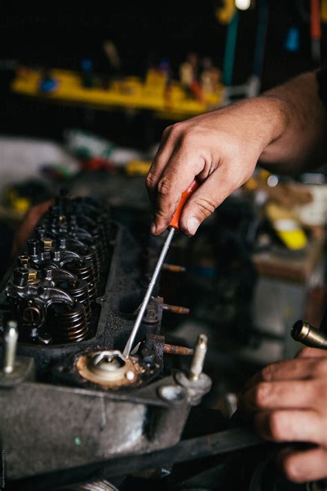 "Fixing A Car Engine" by Stocksy Contributor "Kkgas" - Stocksy