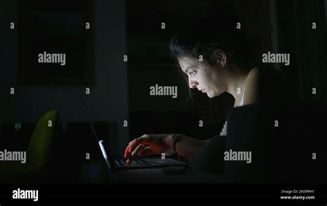 Woman working at night in front of laptop. Person using computer ...