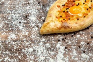 Front view fresh baked bread with cooked egg and flour on brown desk ...