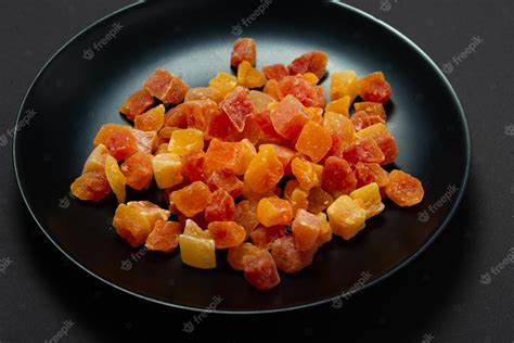 Premium Photo | Candied fruits pineapple and papaya on black background