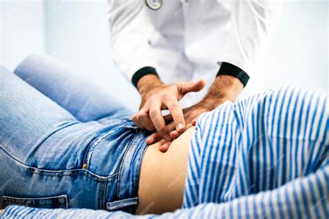 Premium Photo | Doctor palpates patient stomach at gastroenterologist clinic Abdominal medical ...