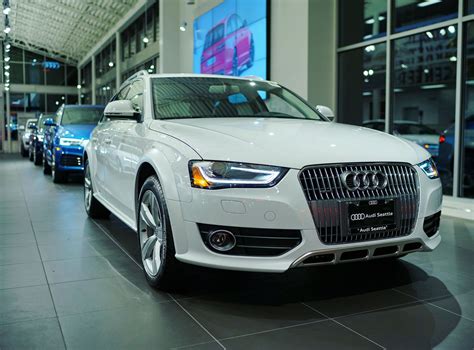an audi dealership with several cars parked in the showroom and people walking by