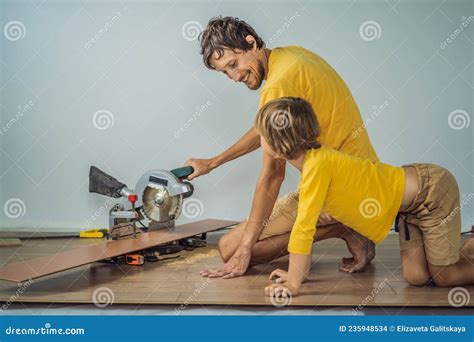 Father and Son Installing New Wooden Laminate Flooring on a Warm Film ...