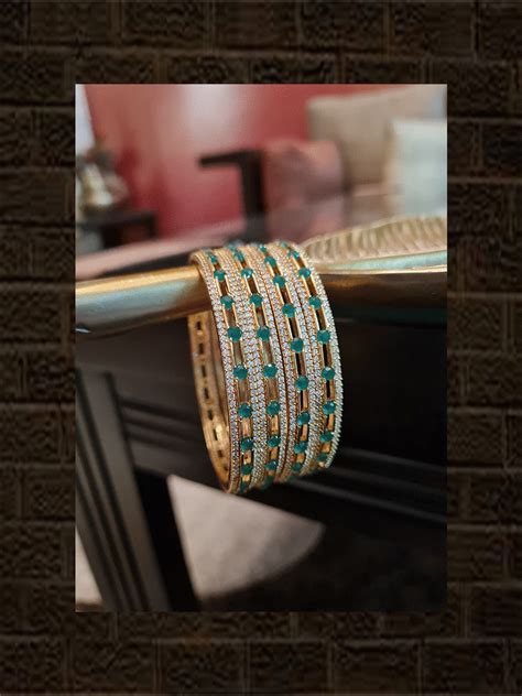 Green stones in between AD line gold finish bangles(set of four ...