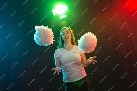 Premium Photo | Cheerleading young woman dancing with pom-poms on ...
