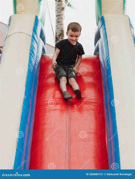 Preschooler Boy Slides Down a Slide on Trampoline Stock Image - Image ...