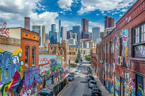 City street bustling with vibrant graffiti artwork on buildings and ...