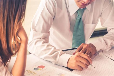 Midsection of business people discussing paperwork on desk | Premium Photo