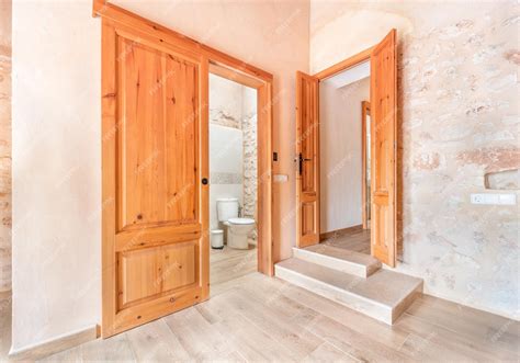 Brązowe drewniane drzwi wejściowe w pustym pokoju obok przesuwanych ...