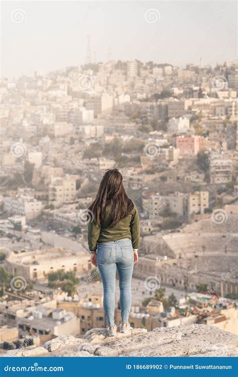 Young Asian Woman Traveller Standing on Stone and Enjoying Top View of Amman Capital City of ...