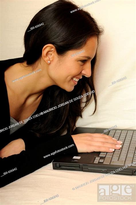 Woman lying on sofa with laptop, Stock Photo, Picture And Rights ...