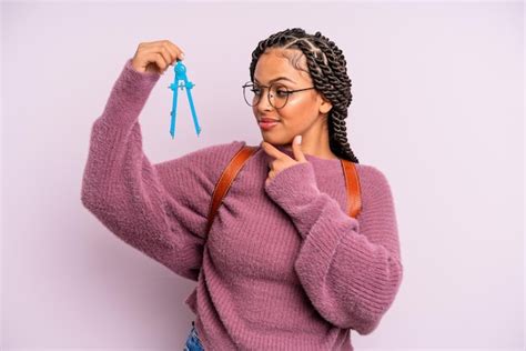 Lächelnd mit einem glücklichen, selbstbewussten Ausdruck mit der Hand ...