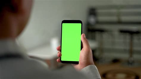 hands swipe up the green screen smartphone with shoulders angle ...