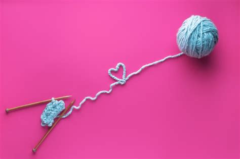 Ball of thread and knitting needles on pink background. handmade and ...