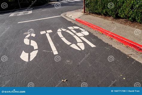 Stop Sign Painted on Asphalt of Red Curb Street at Intersection Stock ...
