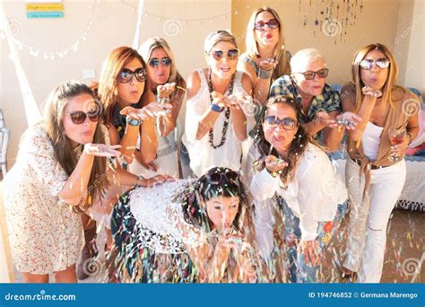 A Group of Nine Beautiful Women Blows on Confetti Celebrating the Party ...