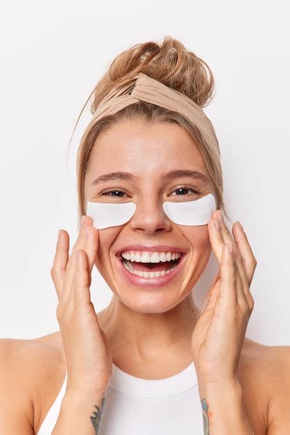 Beauté femme aux cheveux peignés applique des patchs sous les yeux pour ...