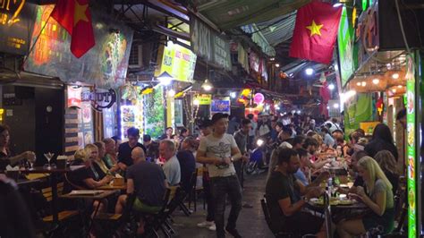 越南制造的横幅悬挂在越南春节期间在餐厅露台上吃饭的越南人的上方。河内老城区的夜生活。还剑老城区视频素材_ID:VCG42N1143444973 ...