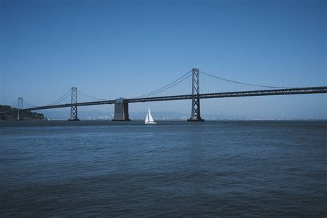 Download Sailing Under Oakland Bay Bridge Wallpaper | Wallpapers.com