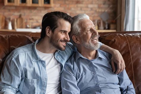 Smiling older caucasian father and adult millennial son sit rest on ...