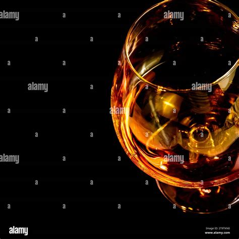 snifter of brandy in elegant typical cognac glass on black background ...