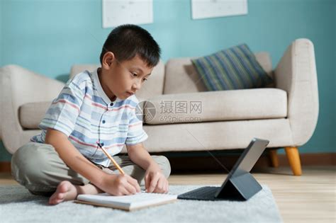 在家工作男生教育亚洲孩与在线教师一起家里学习和做庭作业使用平板电脑上网教学国内的高清图片下载-正版图片307995748-摄图网