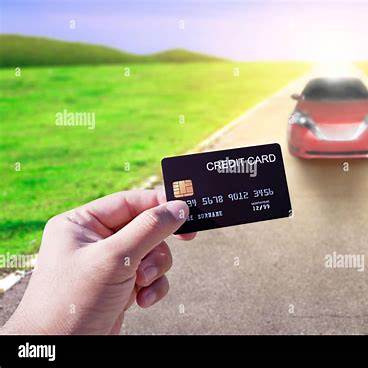 https://c8.alamy.com/comp/2MWH0HB/hand-holding-credit-card-with-car-on-the-road-blurred-background-online-shopping-and-car-rental-concept-2MWH0HB.jpg